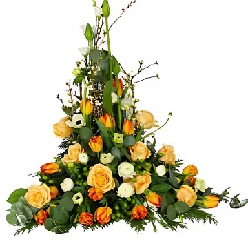 En hög begravningsdekoration med aprikosa snittblommor och grönt.